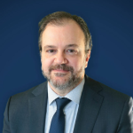 Robert Lattanzio, smiling in picture, wearing a suit with a dress shirt and tie.